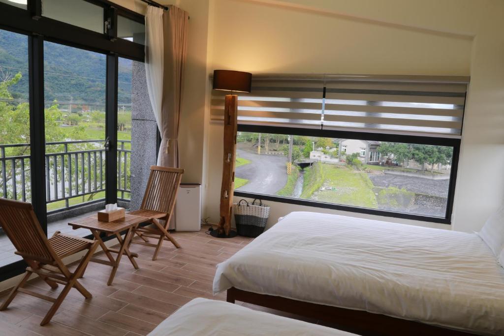 ein Schlafzimmer mit einem Bett und einem großen Fenster in der Unterkunft 安農671民宿 in Sanxing Township