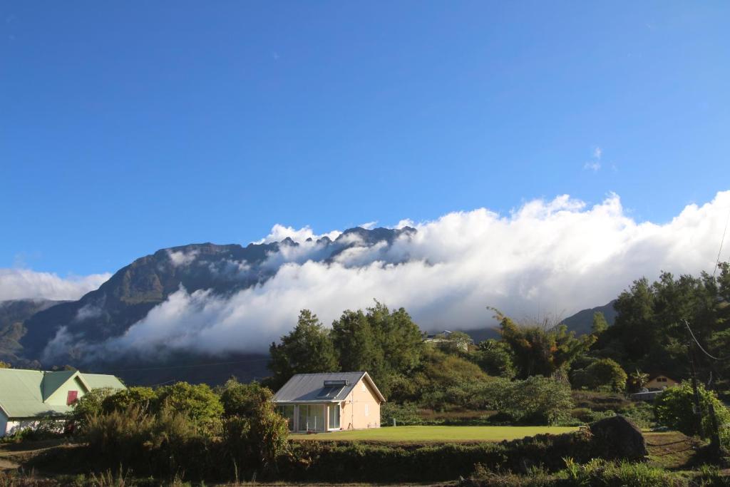 a house in front of a mountain with clouds at lebonair in Salazie