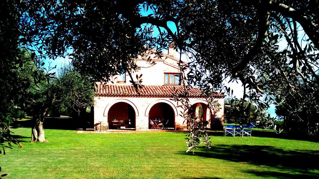 uma casa grande no meio de um campo verde em B&B La Casa tra gli Ulivi em Civitanova Marche