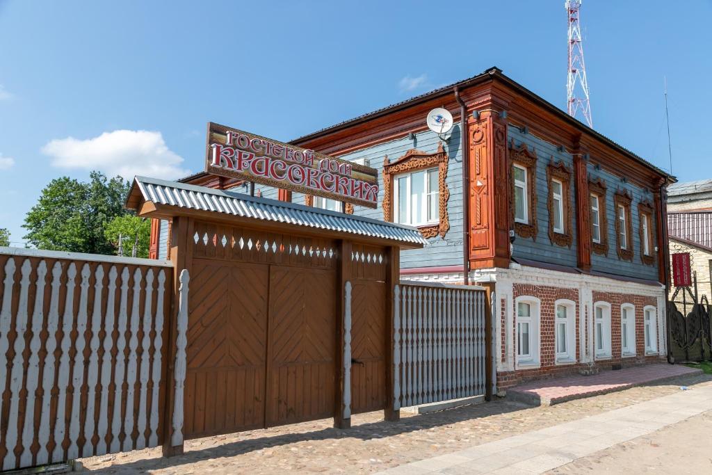 a brown building with a sign on top of a garage at Гостевой дом-музей Красовских in Kirzhach