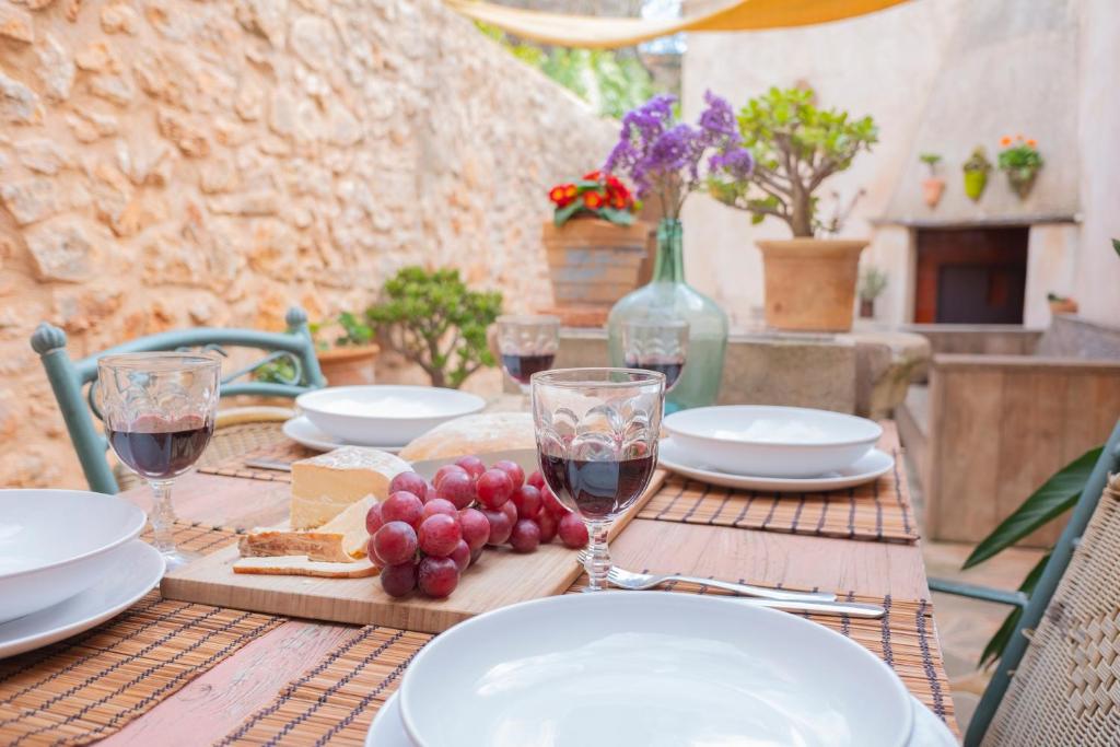 a table with plates and glasses of wine and cheese at Farinera Vella in Santanyi