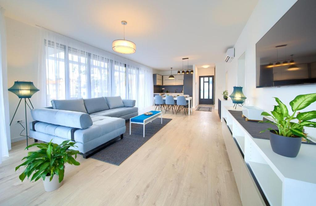 a living room with a blue couch and a table at Apartments Perle in Malinska