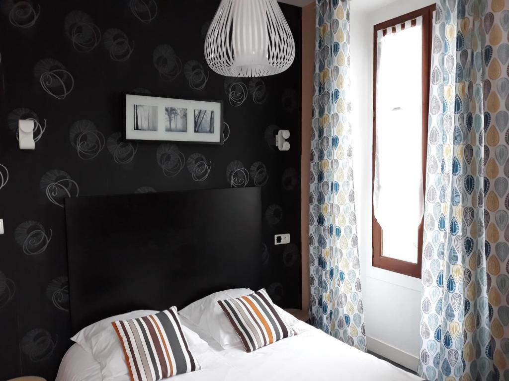 Postel nebo postele na pokoji v ubytování Hôtel Ambroise