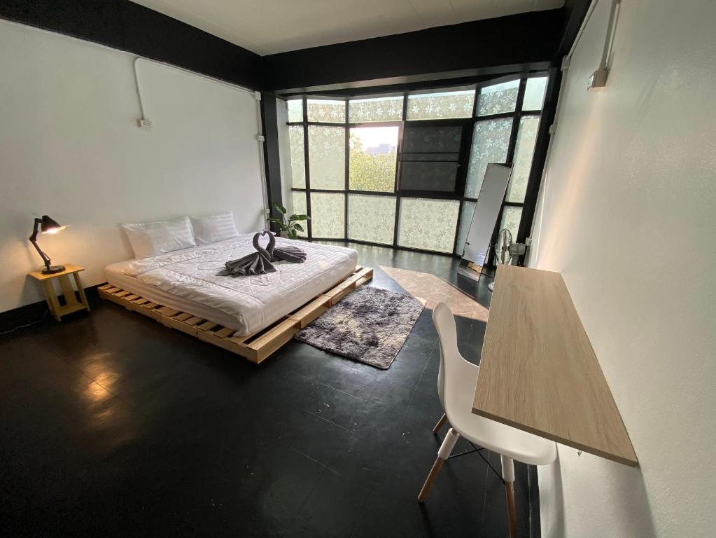 a bedroom with a bed and a large window at FrenTé Chiang Mai in Chiang Mai