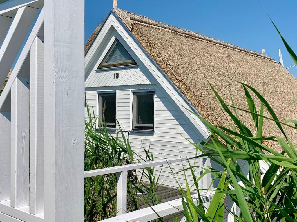 a white house with a straw roof at Seehütte Neusiedlersee inklusive Boot in Rust