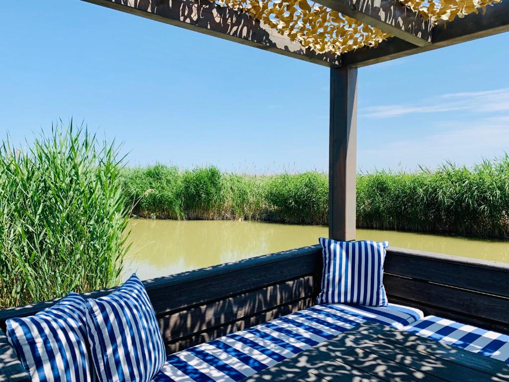 a porch with two chairs and a view of a river at Seehütte Neusiedlersee - Urlaub am Wasser in Rust