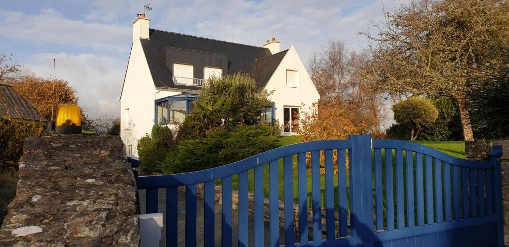 une clôture bleue devant une maison blanche dans l'établissement Appartement 50 m2, Calme, Marche à pied, Proche mer, à Guidel