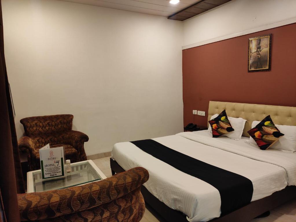 a hotel room with a bed and a chair at Hotel Seven- Center of City Chandigarh in Chandīgarh