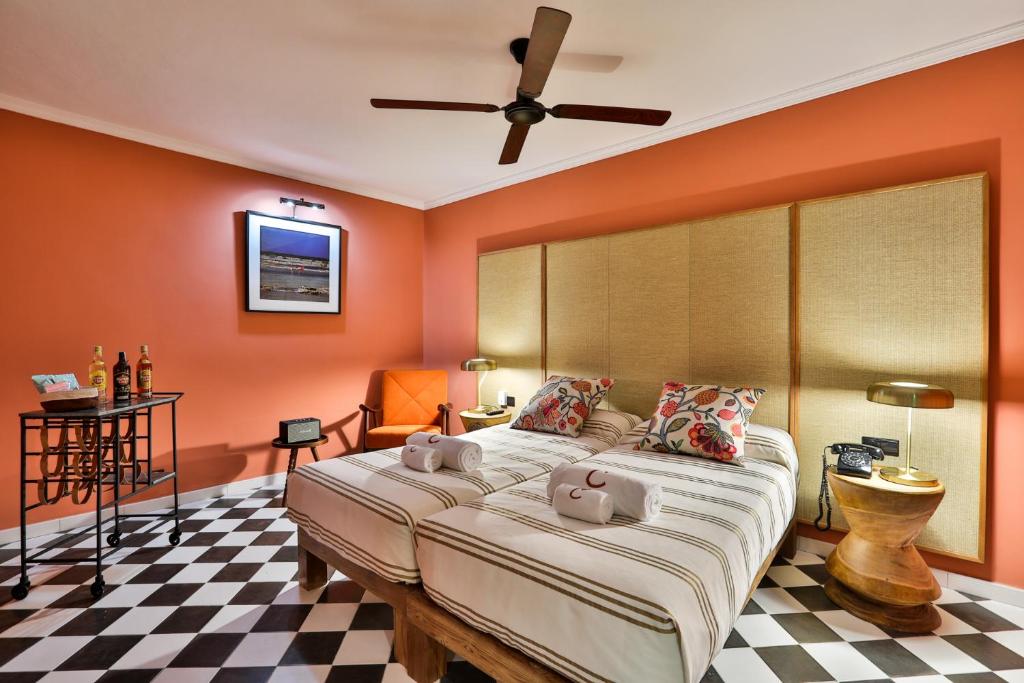 a bedroom with orange walls and a bed with stuffed animals on it at Cubanito Ibiza in San Antonio