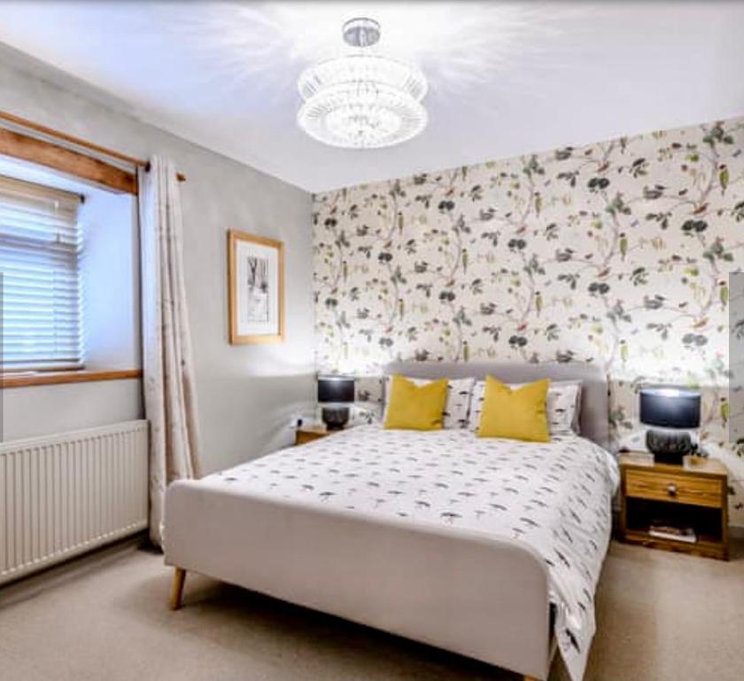 a bedroom with a large white bed with yellow pillows at Chestnut Lodge in East Dereham