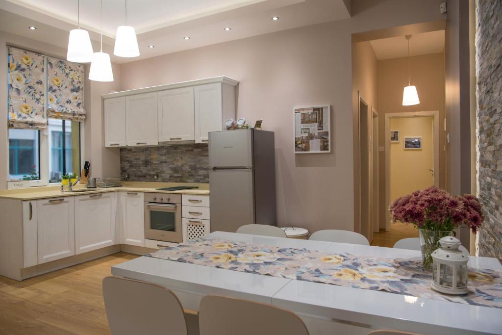 a kitchen with a table with chairs and a refrigerator at The North Tower Apartment in Sofia