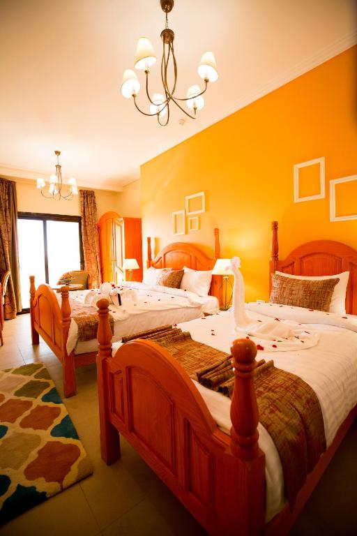 a bedroom with two beds with a swan on them at Holy Family Hotel in Jabal aţ Ţayr