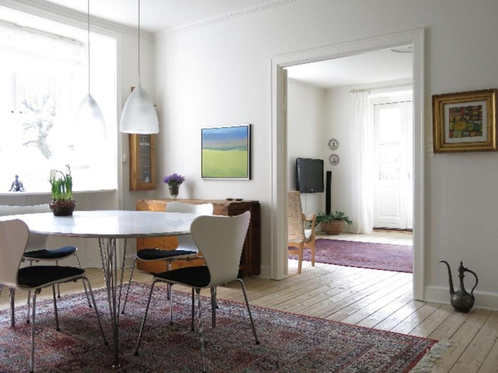 ApartmentInCopenhagen Apartment 701 في كوبنهاغن: غرفة معيشة مع طاولة وكراسي بيضاء
