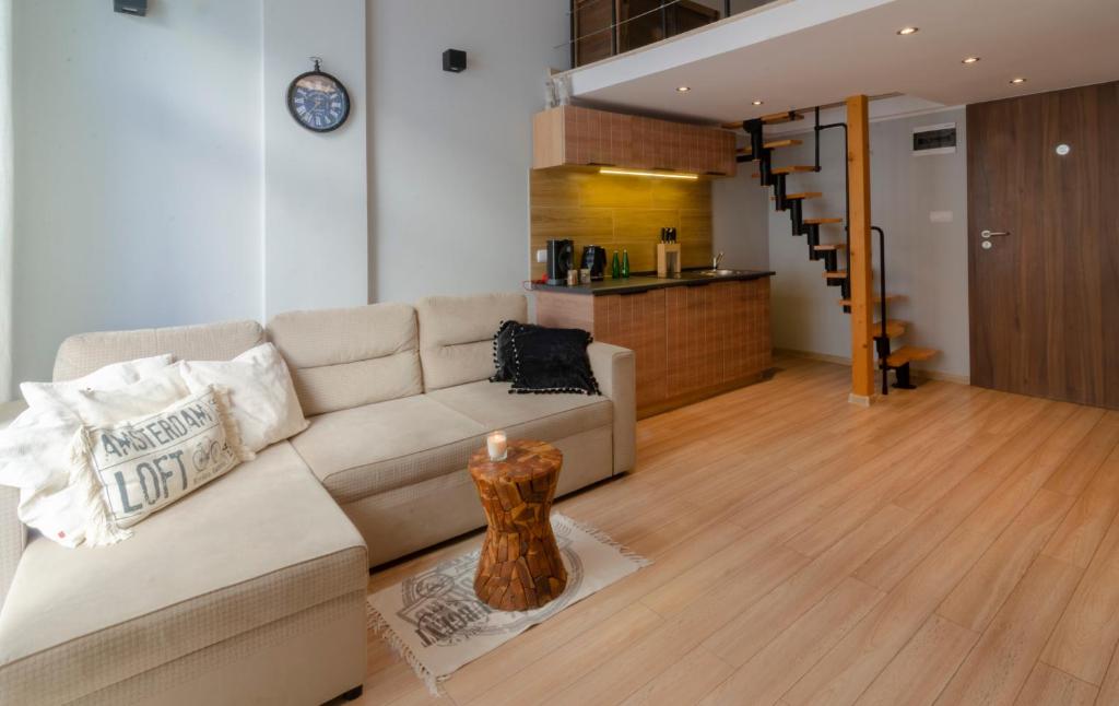 a living room with a couch and a table with a candle at Holiday Home LOFT in Międzyzdroje