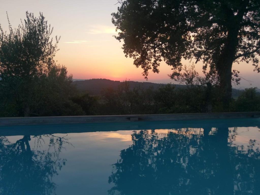 a swimming pool with a sunset in the background at Villa Chiara in Pergine Valdarno