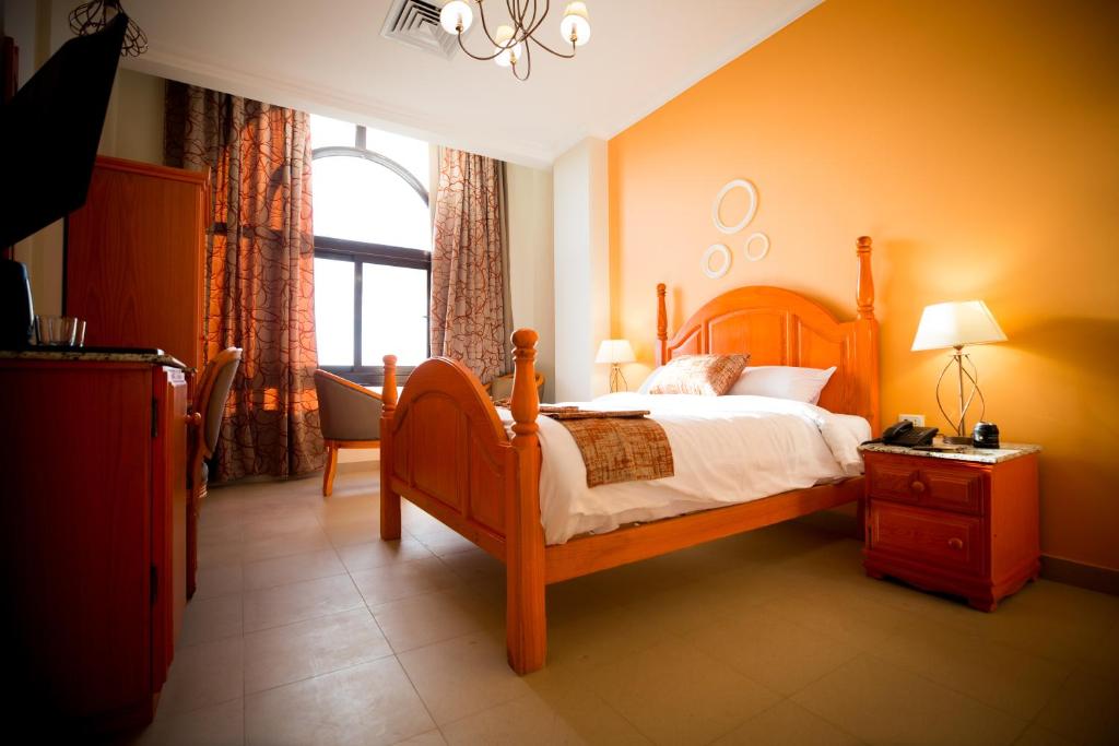 a bedroom with a wooden bed and a window at Holy Family Hotel in Jabal aţ Ţayr
