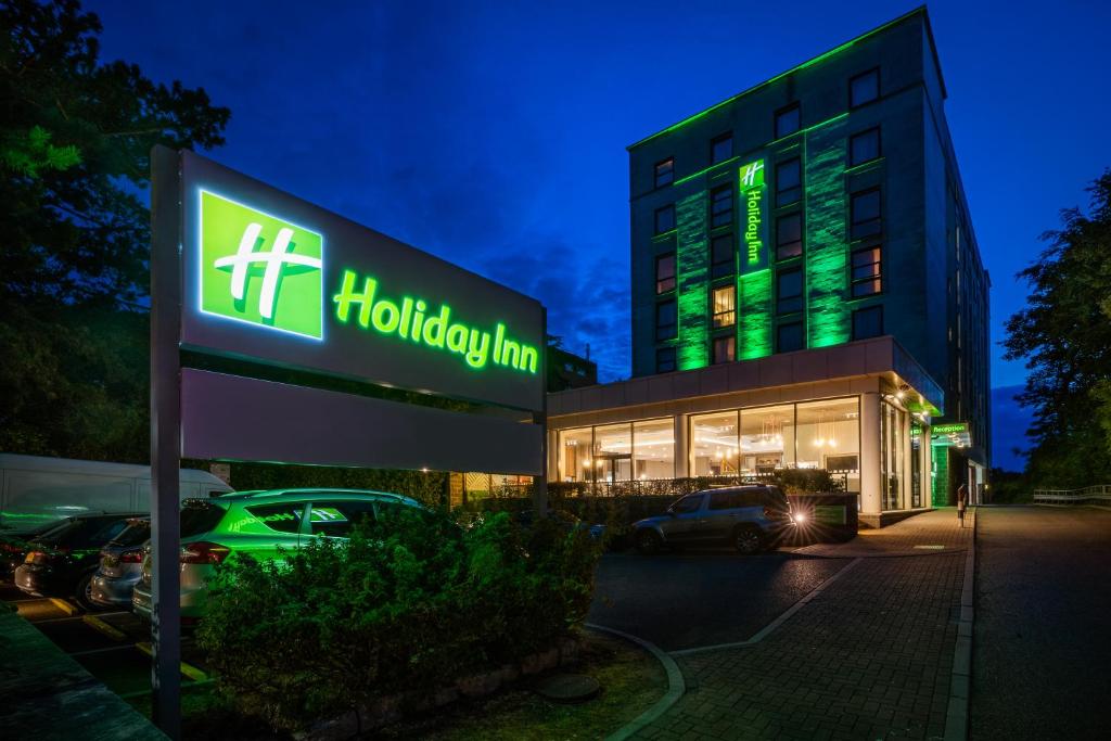 a hotel sign in front of a building at night at Holiday Inn Bournemouth by IHG in Bournemouth