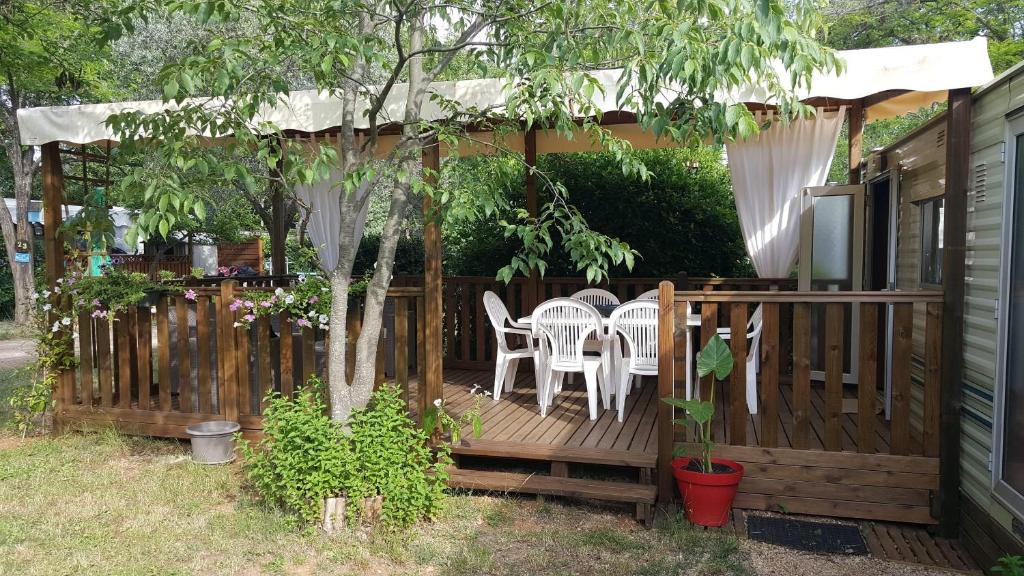 una terraza de madera con mesa y sillas. en Li Sourso, en Aups