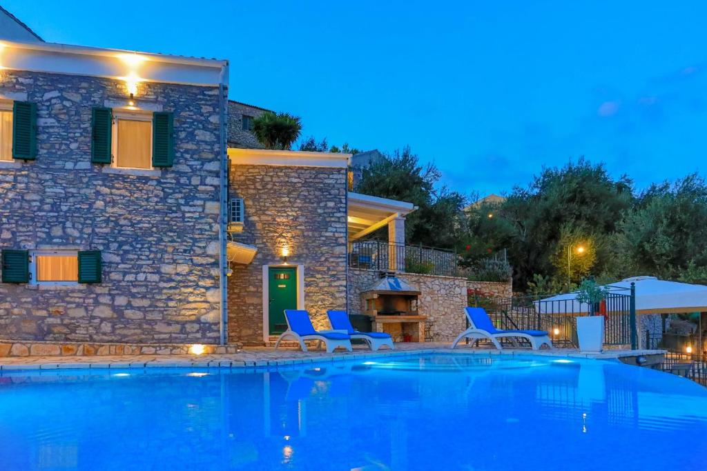 eine Villa mit einem Pool in der Nacht in der Unterkunft Villa Regina: Above Agni, superb views and pool in Kavalléraina