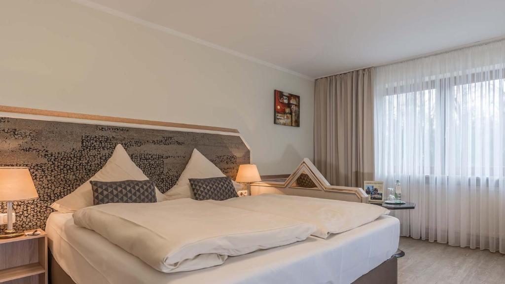 Postel nebo postele na pokoji v ubytování Hotel am Schlosspark