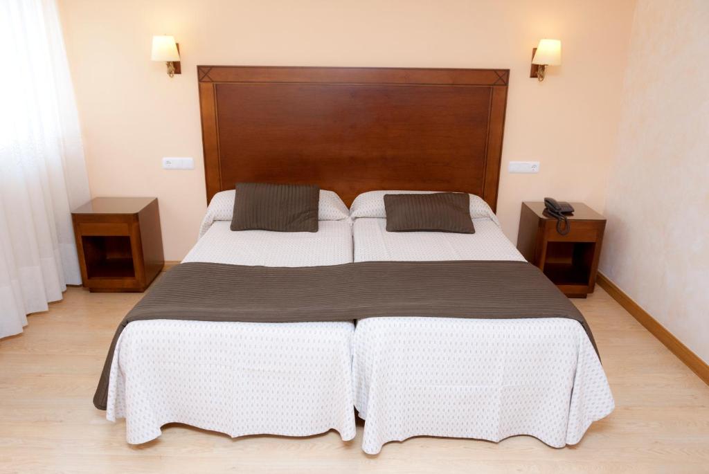 ein Schlafzimmer mit einem großen Bett mit zwei Kissen in der Unterkunft Abadía Burgos Camino Santiago in Burgos
