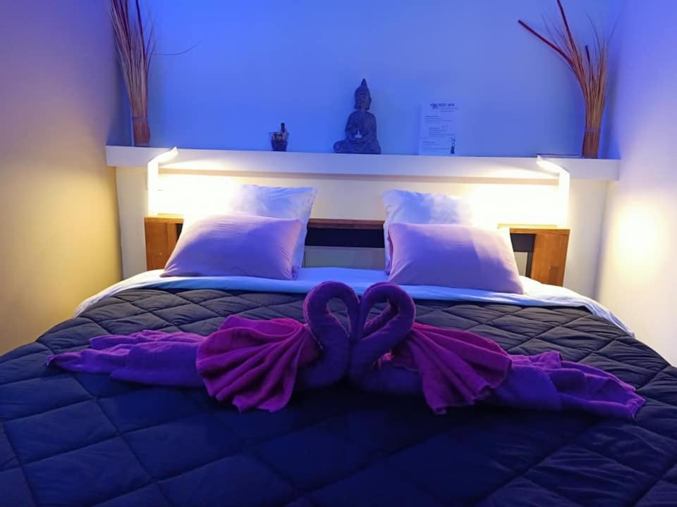 a large bed with a purple bow on it at Mas La Farelle Chambre d&#39;hote,Fitness &amp; Salle de jeux Gratuite &amp; SPA en supplément in Nîmes