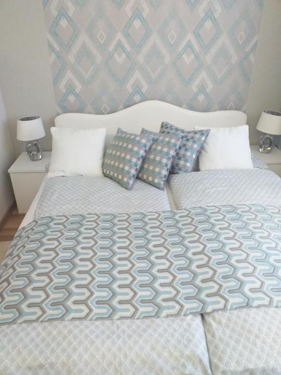 a bedroom with a large bed with two pillows at Elizabeth Apartman 2 in Hévíz
