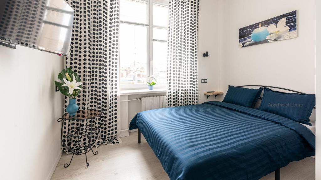 Un dormitorio con una cama azul y una ventana en Aparthotel ЦЕНТР у Центрального Вокзала Минск-Пассажирский, en Minsk