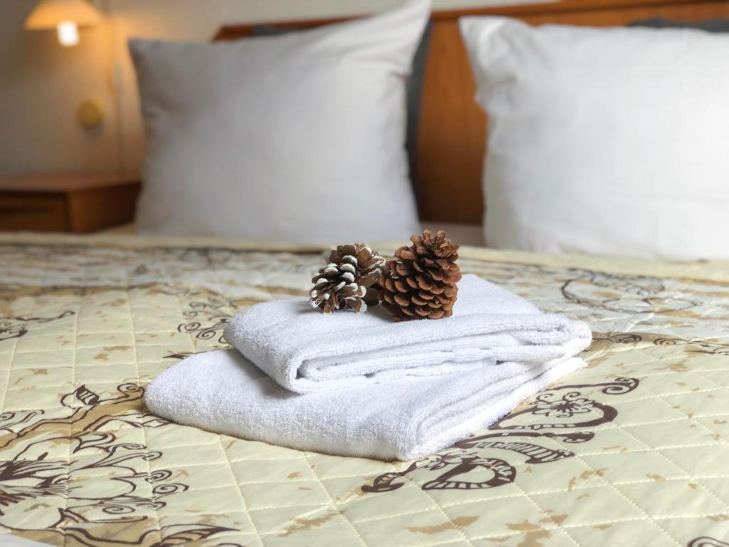 a pile of towels and pine cones on a bed at Hotel Kaiser in Mönchengladbach