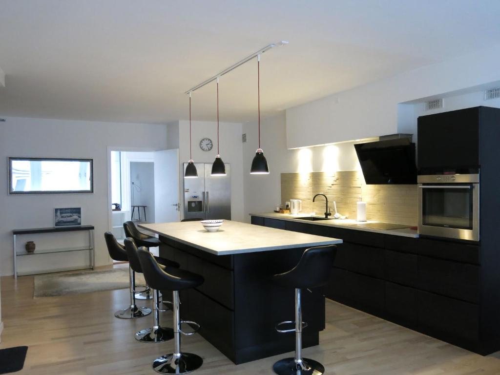 コペンハーゲンにあるApartmentInCopenhagen Apartment 936のバースツール付きの島のあるキッチン