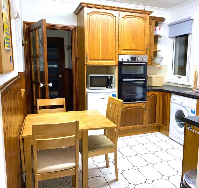 a kitchen with wooden cabinets and a wooden table and chairs at Seaford Lodge Apartments in Weston-super-Mare