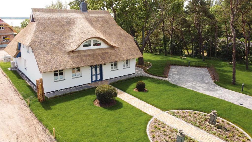 a small white house with a thatched roof at Haus Tadder in Born