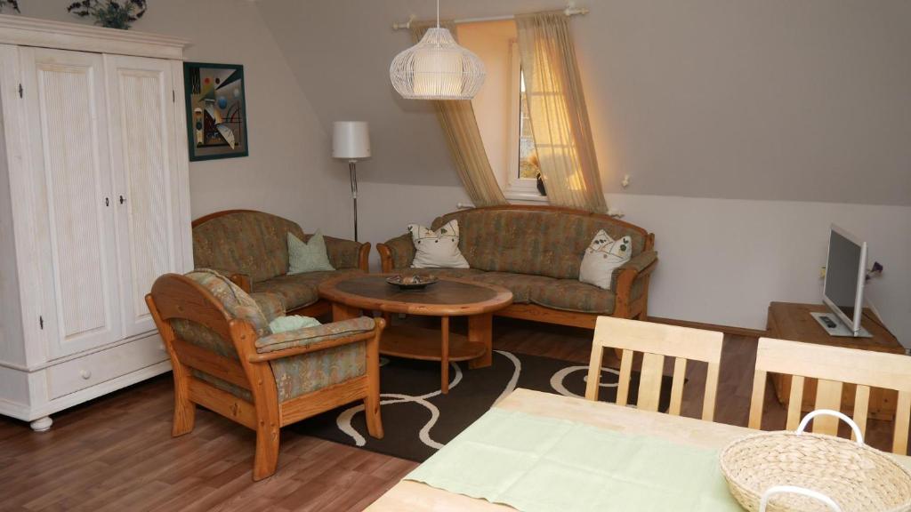 a living room with a couch and a table at Haus "Zur Seebrücke" - Deichblick in Zingst