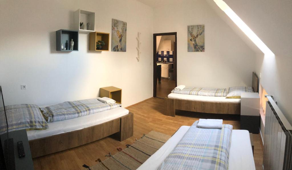 una sala de estar con 2 camas en una habitación en Petra Vendégház en Szekszárd