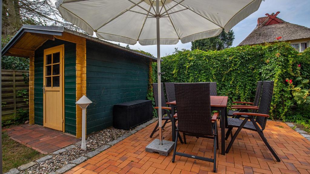 a table with an umbrella next to a small shed at Hol(t)z Hus in Born