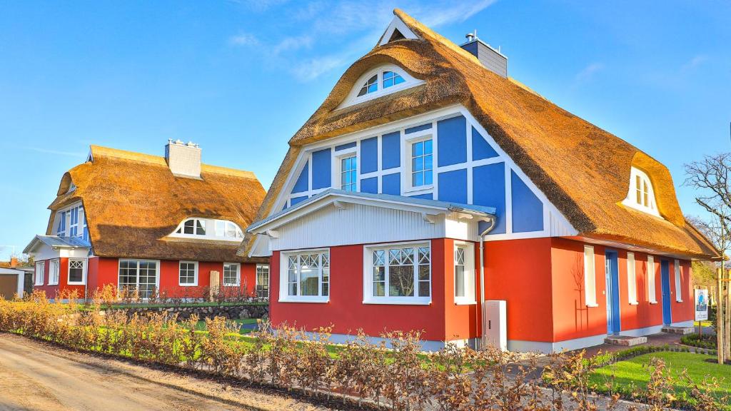 una casa roja y azul con techo marrón en Jade 4, en Born