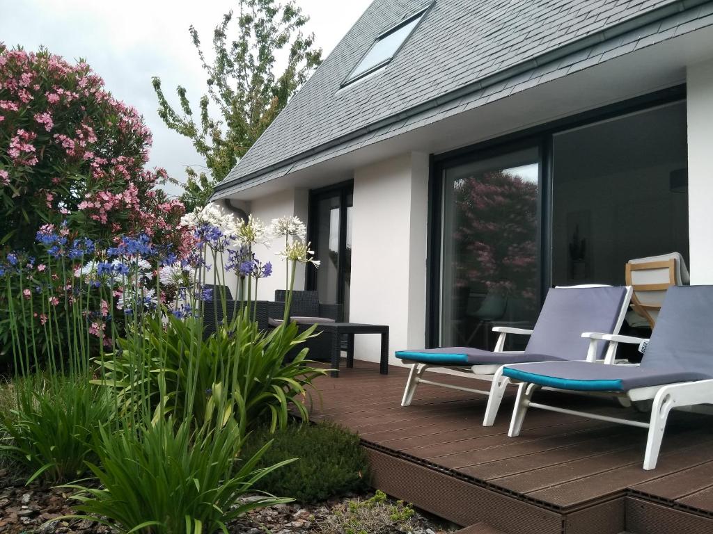 una terraza con sillas y flores en una casa en Villa proche plages, en Fouesnant