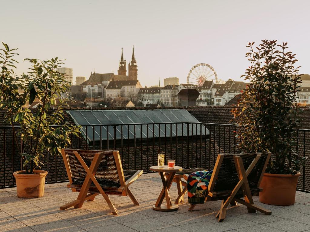 2 sillas y una mesa en la azotea en Boutique & Design Hotel Volkshaus Basel, en Basilea