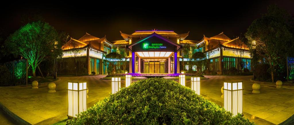 un bâtiment avec des lumières violettes devant lui dans l'établissement Holiday Inn Express Guizhou Qinglong, an IHG Hotel, à Qinglong