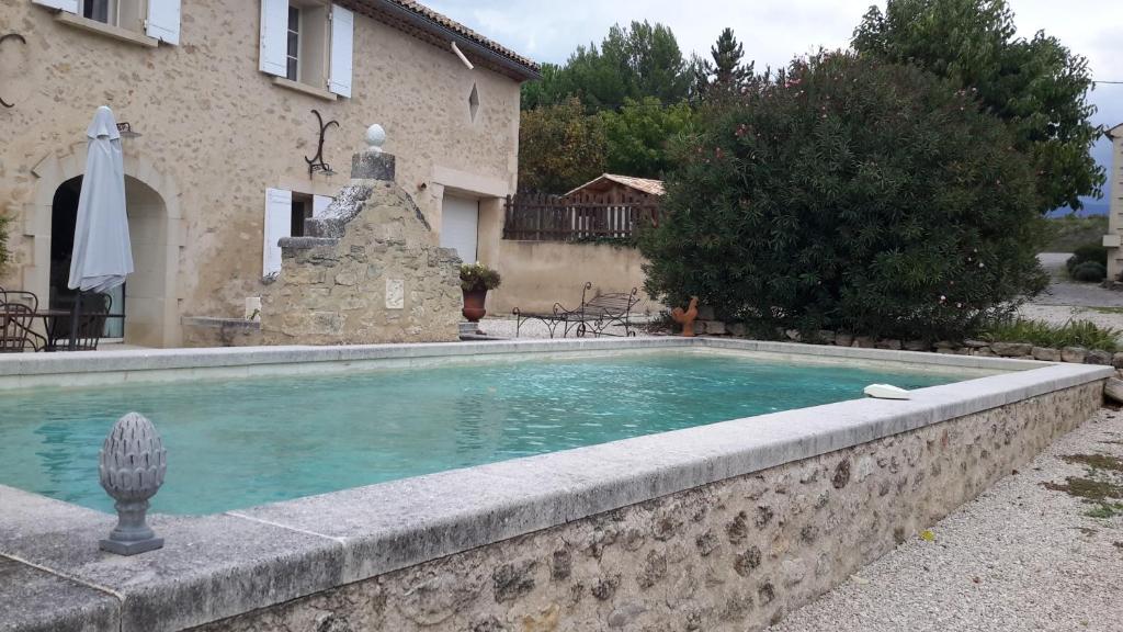 a swimming pool in front of a house at Chambres d'hôtes Le Vignoble in Cucuron