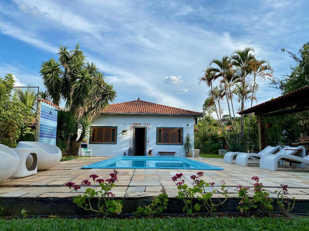 a house with a swimming pool in front of a house at Pousada Nossa Terra in Rio Novo