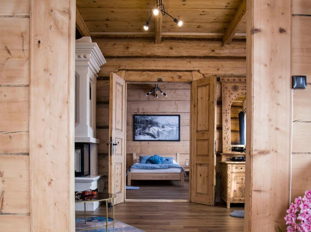 Apartamenty Stare Izby في بورونين: غرفة نوم في كابينة خشب بها سرير