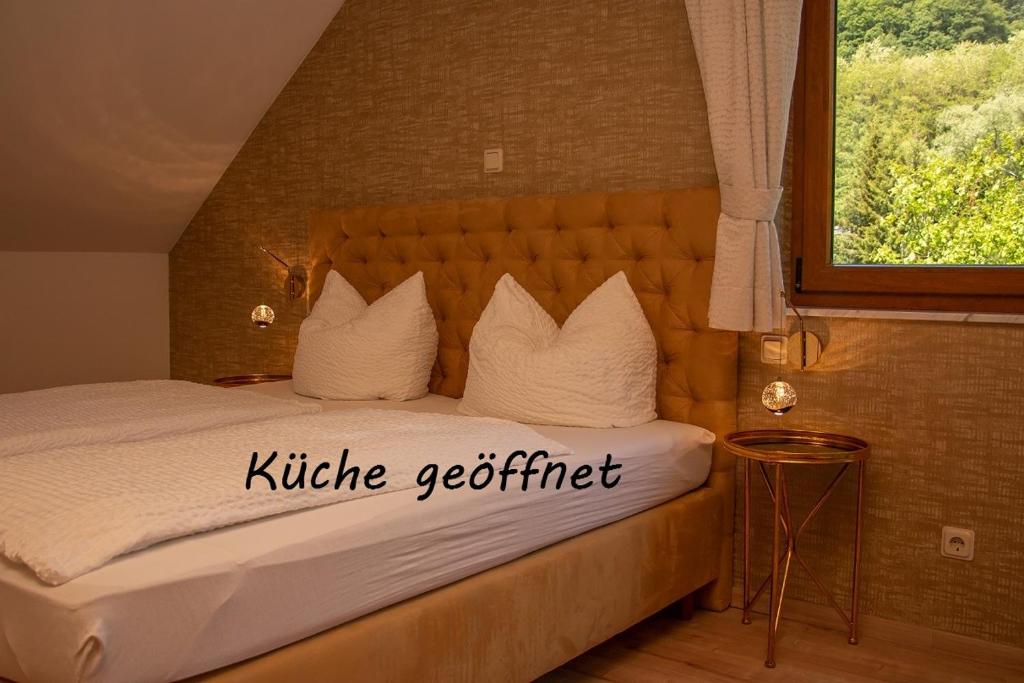 a bedroom with a king sized bed with a hello getmber sign on it at Hotel-Restaurant Laux in Merzig