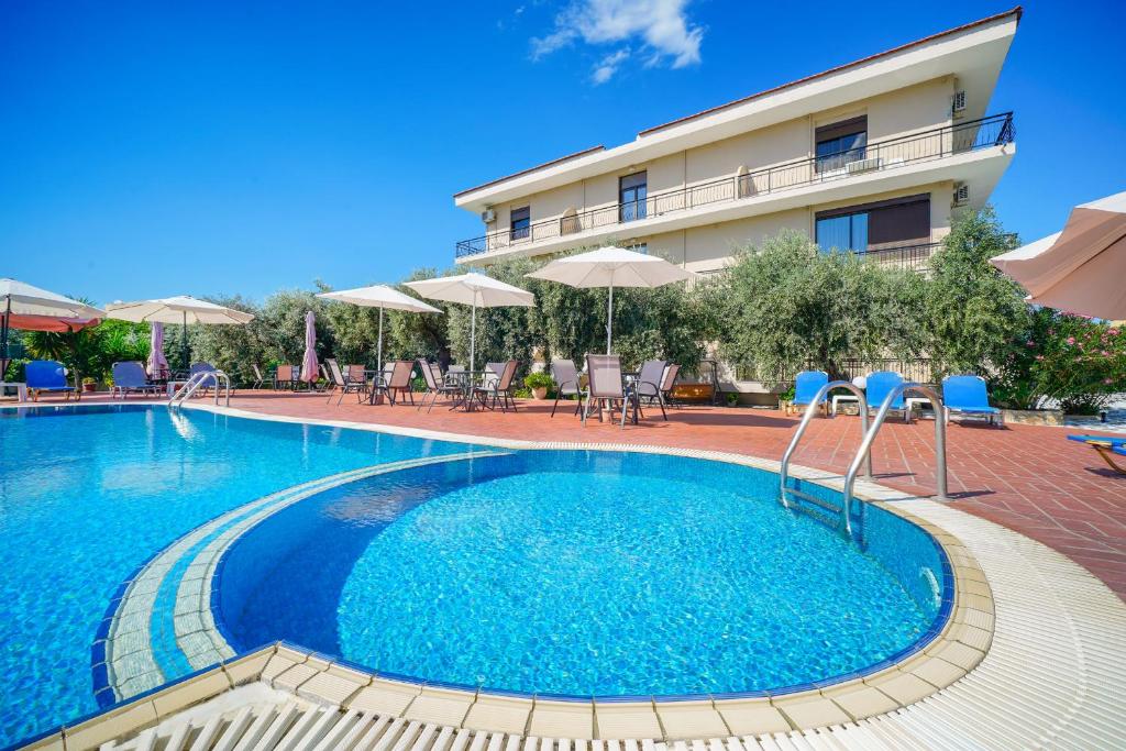 a swimming pool in front of a hotel at Meni Studios in Limenaria