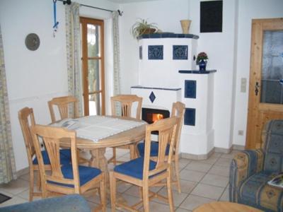 comedor con mesa, sillas y chimenea en Ferienwohnung Wiesenleiten, en Ruhpolding