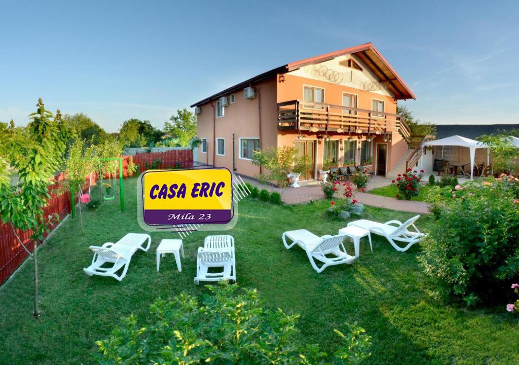 a yard with chairs and a sign in front of a house at Casa ERIC in Mila Douăzeci şi Trei