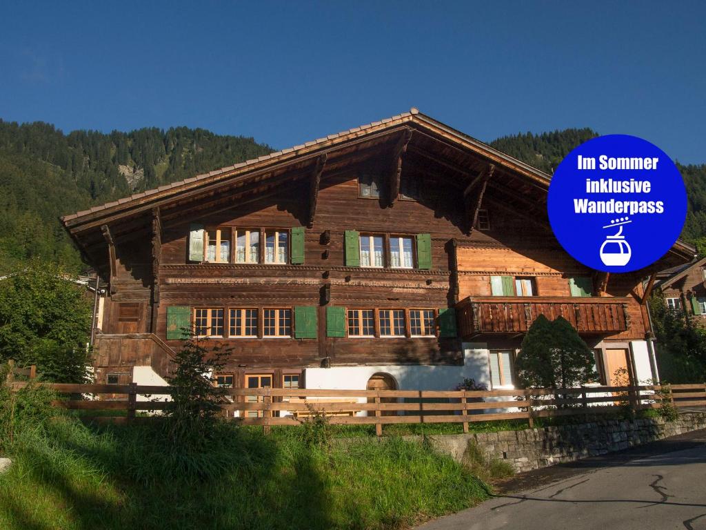 ein großes Holzhaus mit einem Schild davor in der Unterkunft Studio Riseten in Adelboden