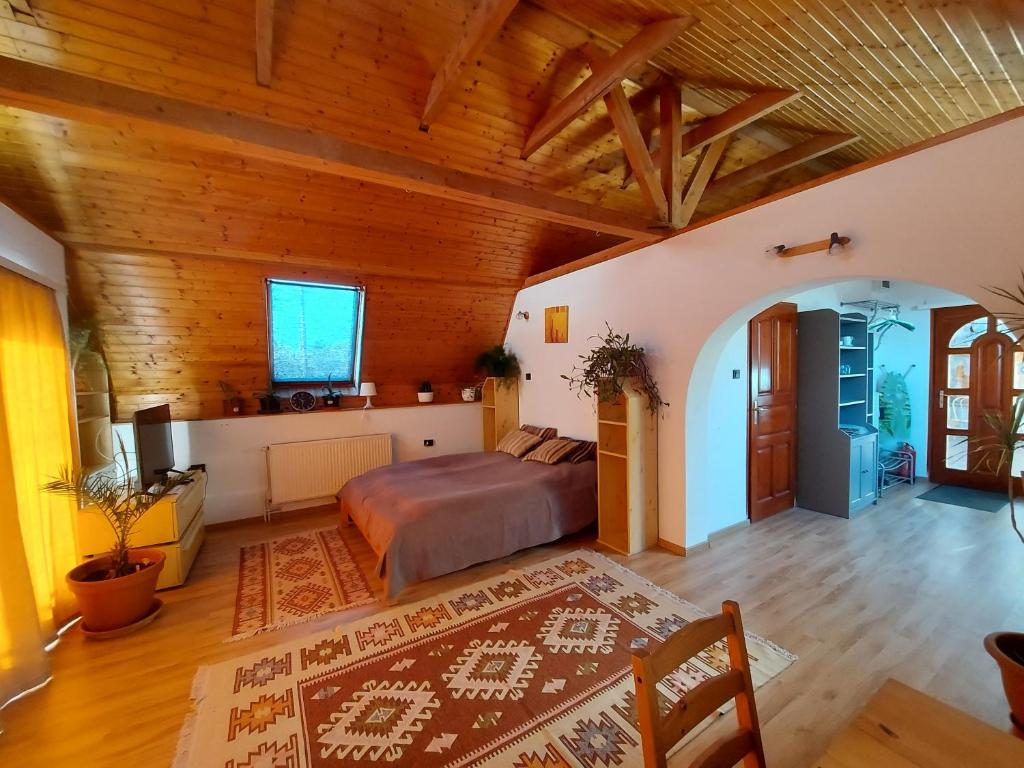 - une chambre avec un lit et un plafond en bois dans l'établissement Attila-Apartman Budaörs, à Budaörs