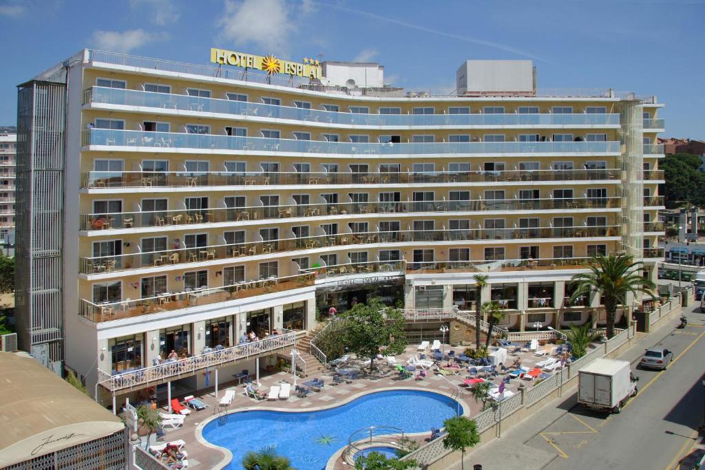 un hotel con piscina frente a un edificio en Hotel Esplai, en Calella