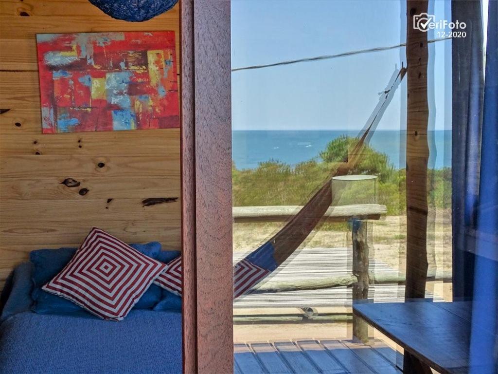 a room with a hammock and a view of the ocean at OHANA in Punta Del Diablo
